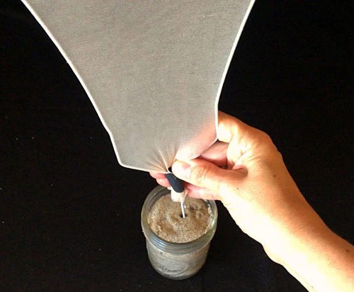 Assembled fog catcher placed upright in a jar of sand.