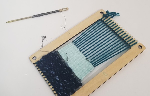 Conductive thread wrapped around tapestry needle.