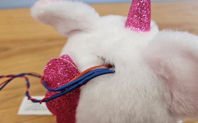 Wires inserted into a slot in the back of the stuffed animal's head