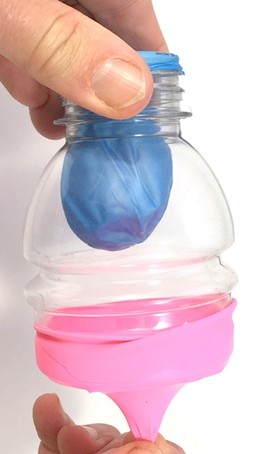 A lung model where a person pulls the knot away from the model lung. The model lung is round, filled with air.