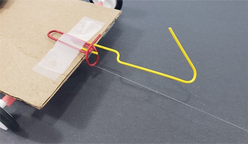 Wire is attached to a paperclip on the chassis of a solar powered car