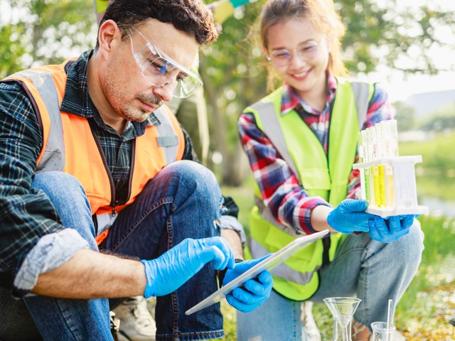 Environmental scientists sampling contaminated water in field