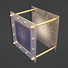 Whipple shield showing initial impact hole and spread-out debris pattern