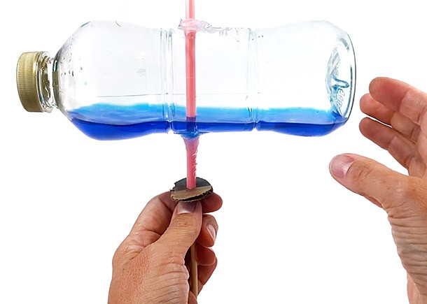 Hands holding an assembled bottle centrifuge.