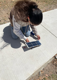 Student working on solar sprint car outside