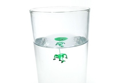 A glass of water with a drop of oil-food color mixture added, showing a burst of food coloring under water.