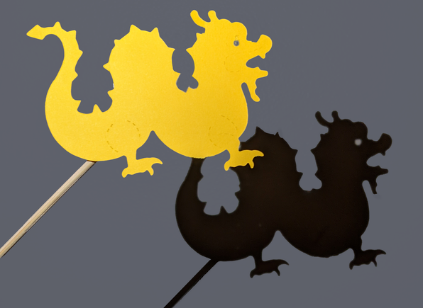 Dragon shadow puppet with shadow on the wall