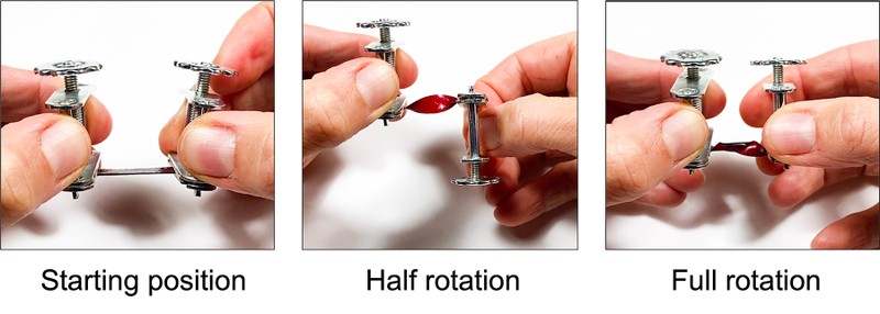  Two hands holding the two compressor clamps with the sample in the middle.