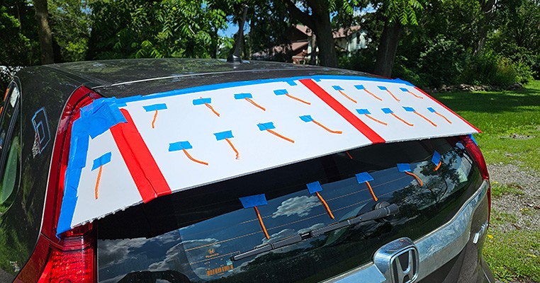 Back of a car fitted with a foam board device and lengths of yarn for indicating airflow.