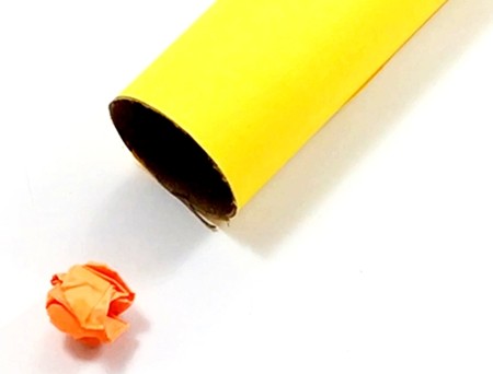 A crumpled-up paper ball place so a blow should easily carry it into a tube.