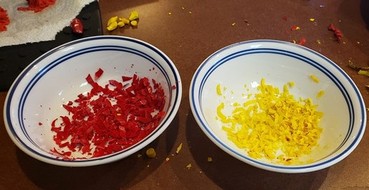 Different color crayon shavings in two different bowls.