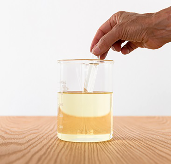Jar with water and a stirring stick within that is hard to see