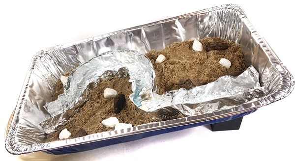 Setup for modeling the water flow in a river model inside an aluminum pan.