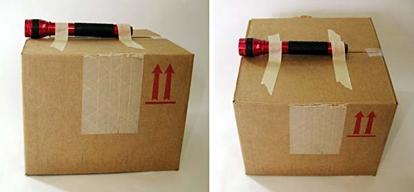 A flashlight taped to the top of a cardboard box