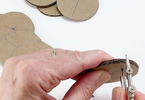 The sharp point of a compass piercing a stack of 2 well-aligned circles.