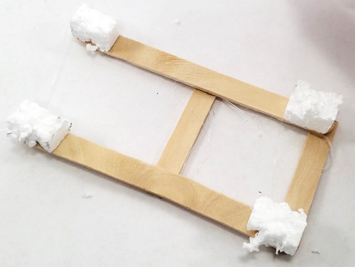 Foam pieces glued to bottom of popsicle stick boat