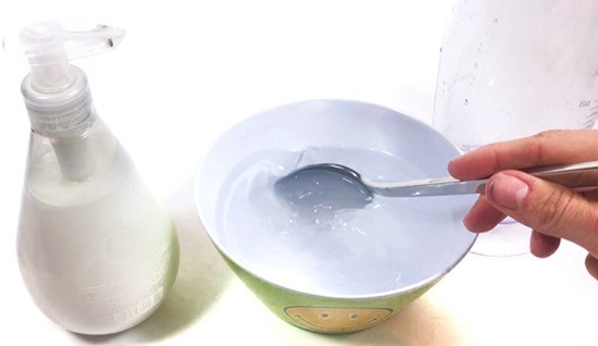A bowl with soapy water that is stirred with a spoon.