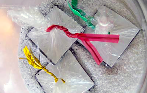 Model antibodies made with plastic wrap and magnetic tape in a jar of salt and iron filings to represent human body, cells, and pathogens