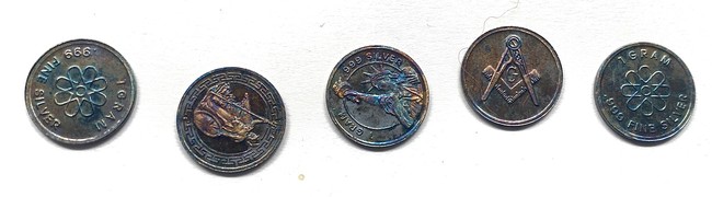Five tarnished silver coins.  