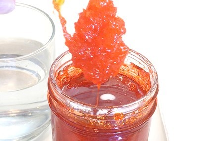 Rock candy being pulled up from a jar with thick syrup.