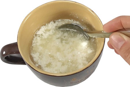 Milk separates into curds and whey in a mug
