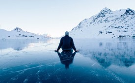 A man sitting on a frozen lake