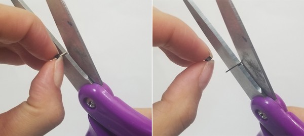 Fingers pinching black plastic piece of male header pins while scissors are pinching metal wire. Fingers pinching black plastic piece of male header pins while scissors have removed metal wire