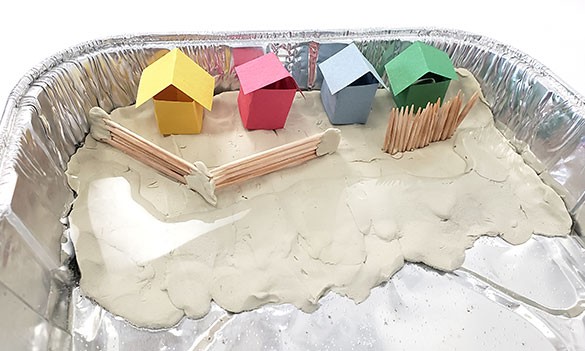 Toothpick wall built on the beach to protect the houses. The wall is in two segments, one with horizontal toothpicks, one with vertical toothpicks.