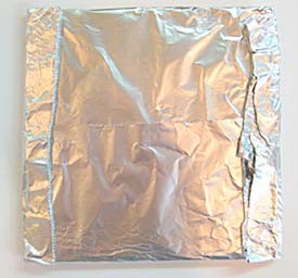 A cardboard square is wrapped in a layer of aluminum foil