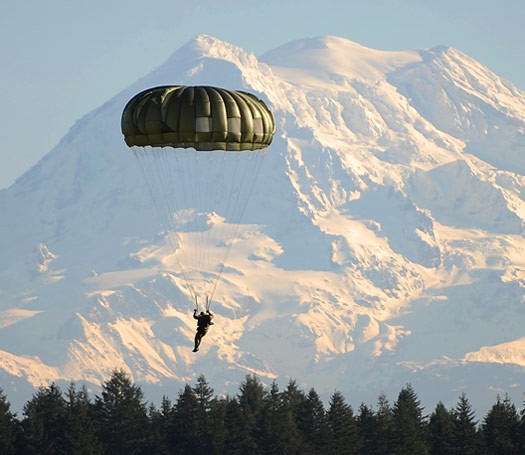 Photo of a person in the air with an opened parachute