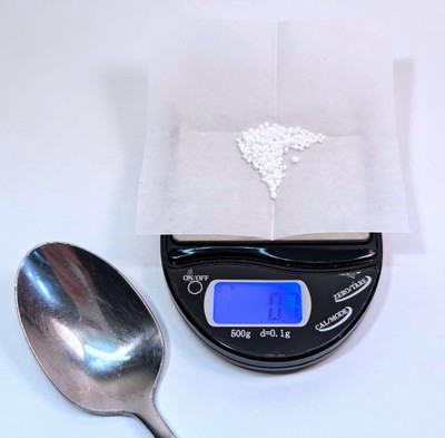 Picture of a scale and spoon weighing out 0.7 g.