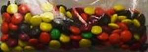 Clear bag full of yellow, brown, orange, and red MMs in near equal proportions and only two green MMs.