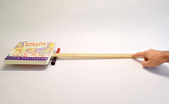 A yard stick and a marker form a lever that lifts a book with the effort of one finger