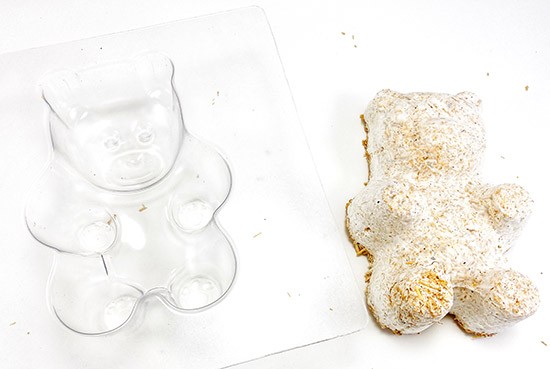 A growing container in the form of a bear and the molded 'bear' made of organic material bonded by mushroom roots