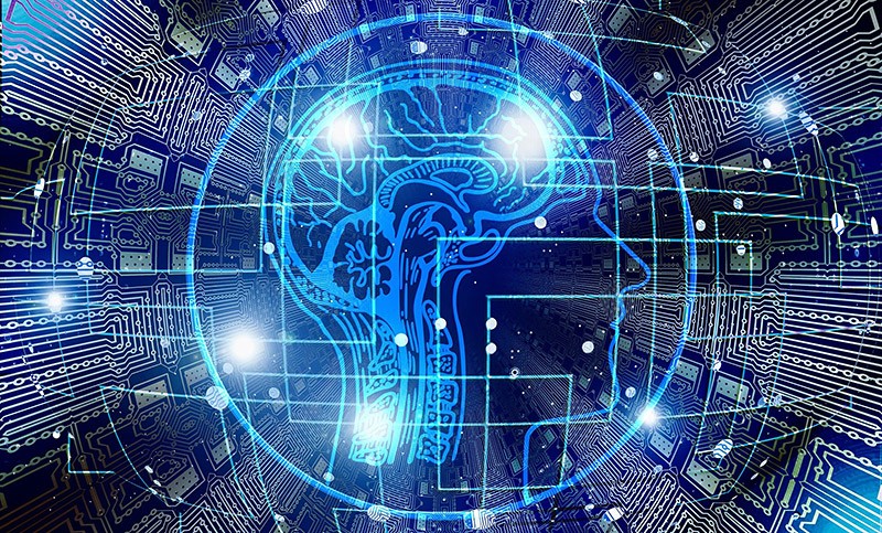 A graphic of a human brain with wires connected to circuit-like traces in the background 