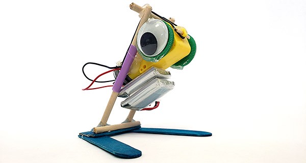 A jumping robot made from popsicle sticks, wooden dowels, straws, and rubber bands.