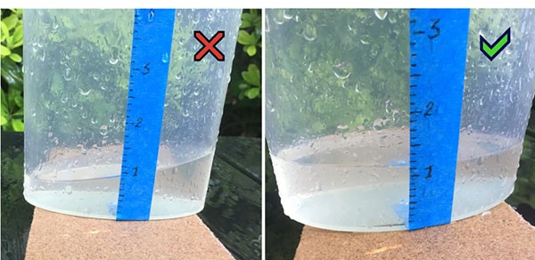 Photo shows a rain gauge placed on a slanted surface on the left and a flat surface on the right