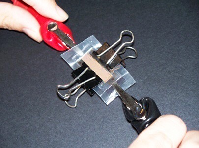 Alligator clips attached to either end of a solar cell made of conductive glass slides.