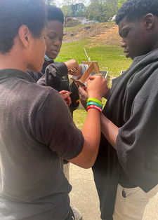 Student working on solar sprint car outside