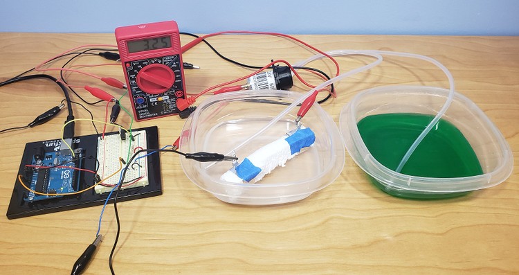 Arduino, multimeter, and two containers of water set up for artificial pancreas experiment