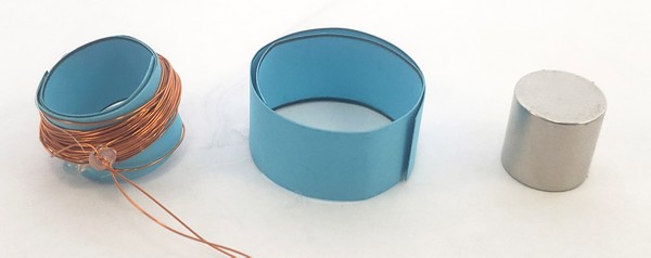 Paper tube with wire coil next to removed inner paper strip and magnet.