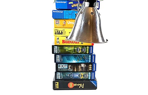 A lamp clamped to a stack of books.