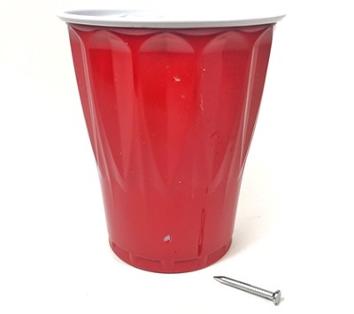 A cup with a small hole at the bottom of its side wall.