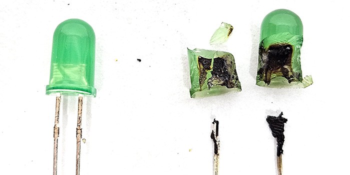 An intact new LED next to an LED that burned so badly that it split in half.