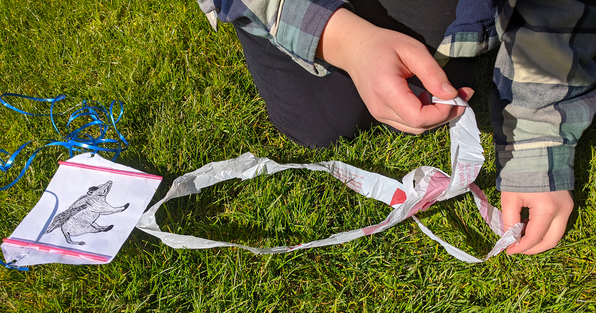 Student adjusting the tails of a homemade sled kite