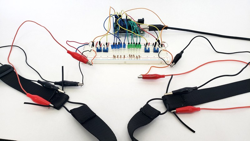Arduino circuit with alligator clips connecting the breadboard to the rubber cords on the chest and belly sensors 