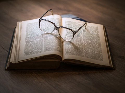a pair of glasses sitting on an open book