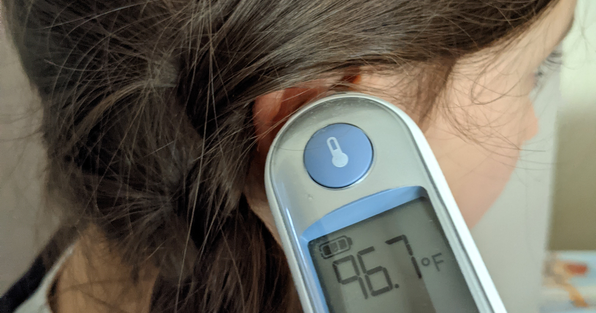 Student having her temperature taken using a thermometer in the ear
