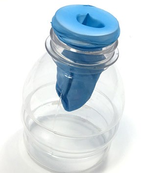 A balloon's neck is folded over the top of the bottle and the body of the balloon hangs inside the bottle. The bottom of the bottle is cut off about 3/4 inch below the lowest point of the balloon.