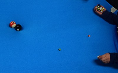 Two billiard balls at the center of a stretched blue sheet